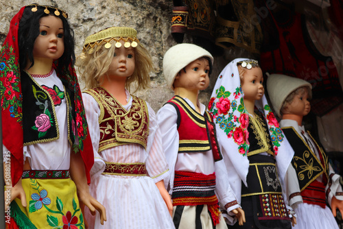 Ancient Albanian dolls (toys) in traditional costumes. Albania, souvenir shop, market, culture.