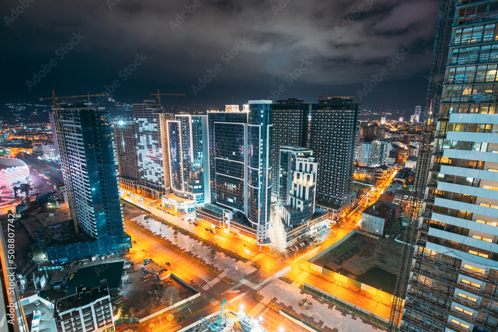 Obraz premium Street Night City Traffic and highrise houses . Elevated View Cityscape Skyline. Night Light Lighting. Industrial concept. Building industry.