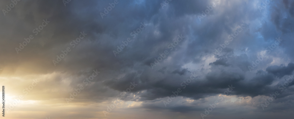 Dramatic sunset sky with dark rainy clouds. Nature background. Sky panorama.