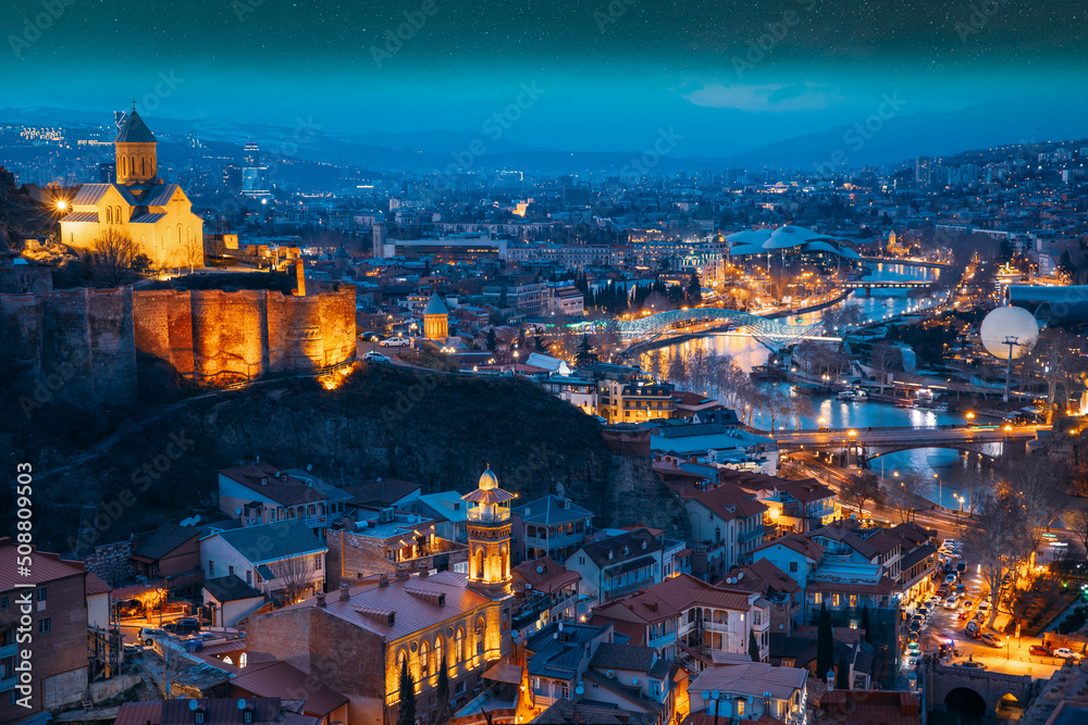 Tbilisi, Georgia. starry sky night sky above cityscape skyline, Scenic View Old Historic District Of Kala. Urban Night Cityscape. Evening Scenic. blue hour. altered sky. Elevated Top View Of Famous