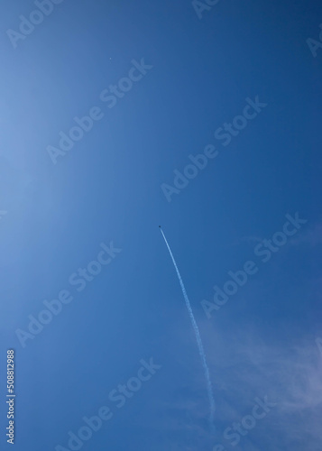 Blue sky with white clouds and a small plane left a trail place for text template