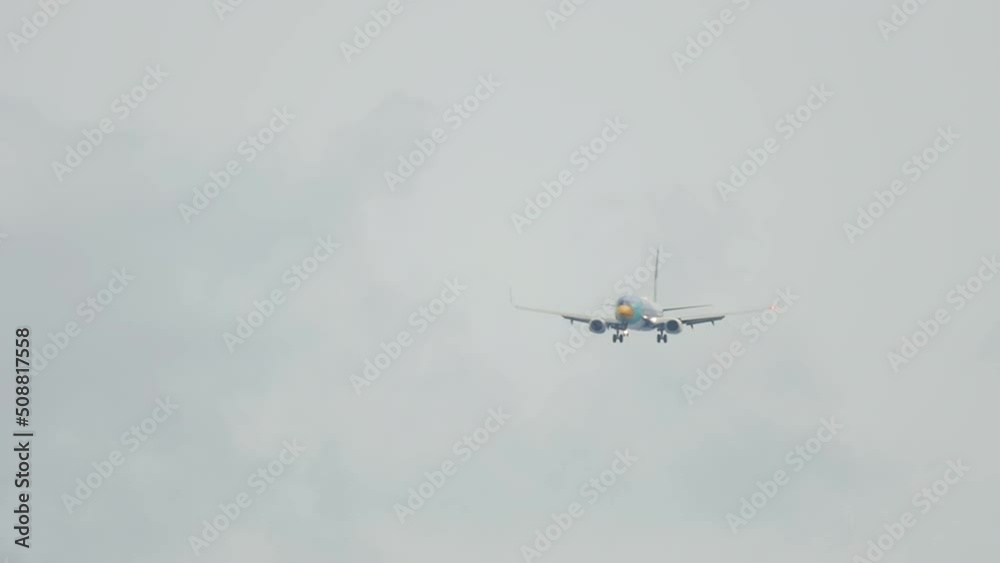 Long shot of jet airplane descending for landing in bad rainy weather. Tourism and travel concept Long shot of jet airplane descending for landing in bad rainy weather. Tourism and travel concept