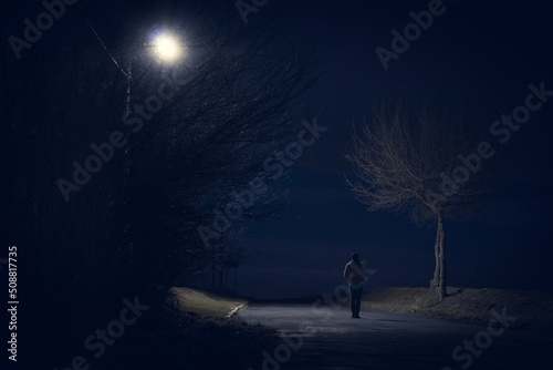Sylwetka człowieka spacerującego nocą