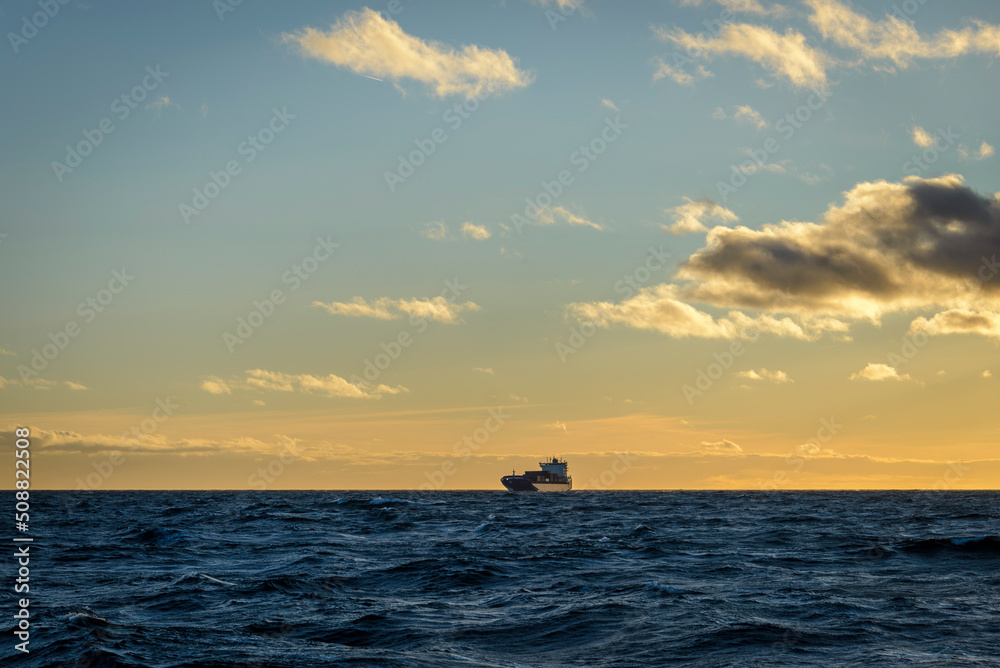 Ship at sea. Beautiful seascape waves and sky with clouds with beautiful lighting. Golden hour. Ship at sea. Beautiful seascape waves and sky with clouds with beautiful lighting. Golden hour.