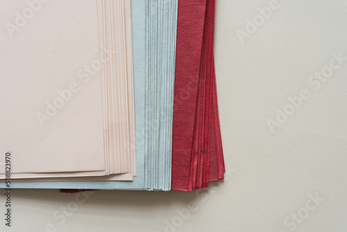 stack of crafting paper in dusty pink, gray, and deep red