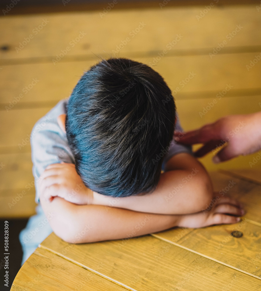 Niño pequeño sentado en una cafeteria Niño pequeño sentado en una cafeteria