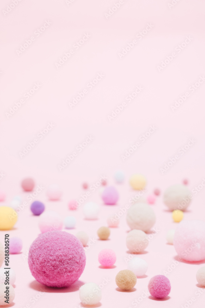 Fluffy colorfull cotton balls variety sizes set on pastel pink seamless background