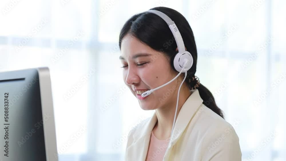 Beautiful Asian woman, she is a call center employee of an Internet and telephone company, she is responsible for providing service and assistance to customers through the phone. Call center concept. Beautiful Asian woman, she is a call center employee of an Internet and telephone company, she is responsible for providing service and assistance to customers through the phone. Call center concept.