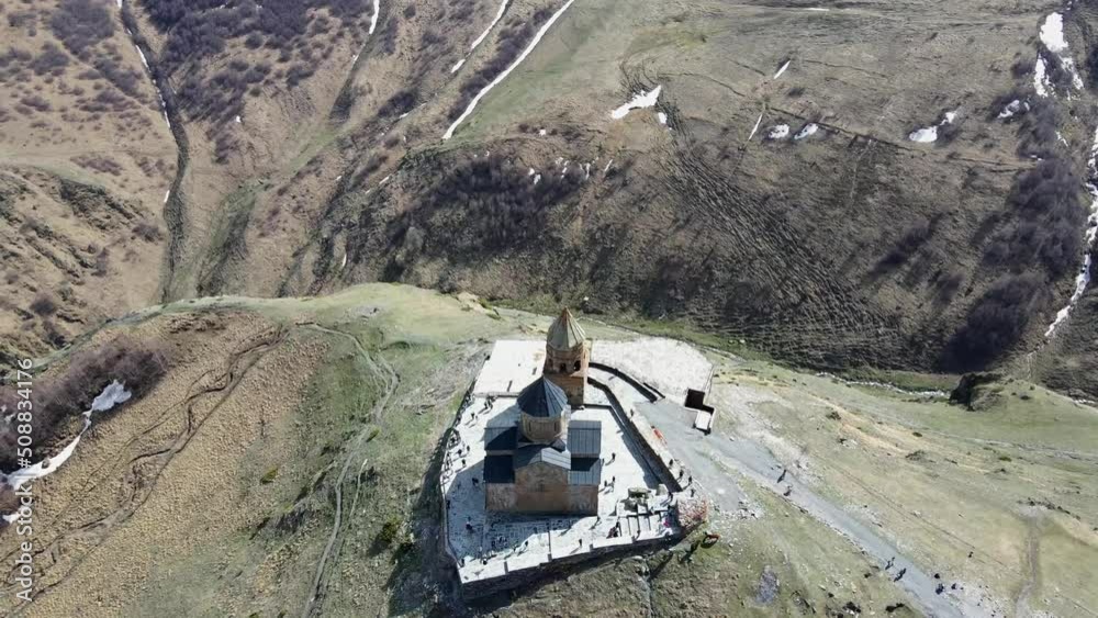 Camera drone flies around and descends to Holy Trinity Church (Gergeti Trinity Church) near the village of Stepantsminda in Georgia Camera drone flies around and descends to Holy Trinity Church (Gergeti Trinity Church) near the village of Stepantsminda in Georgia