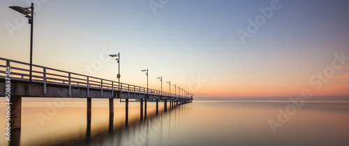 sunrise over the pier in Mechelinki. Panorama photo of Baltic beach