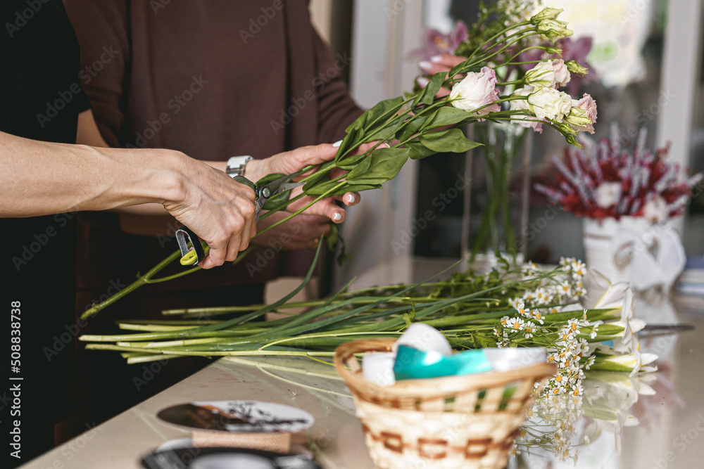 woman's hands making bouquet of flowers
