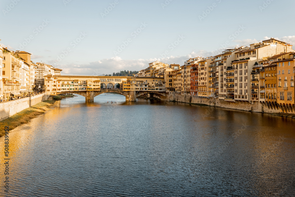 Naklejka premium Sunset view on famous Old bridge called Ponte Vecchio on Arno river in Florence, Italy. Concept of traveling Italy, visiting italian landmarks