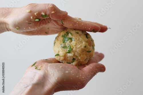 Hands making Semmelknödel. Preparing austrian traditional dumplings with parsley. photo