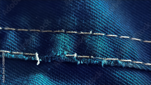 Close-up old work uniform with scuffs on a lowercase seam of blue denim