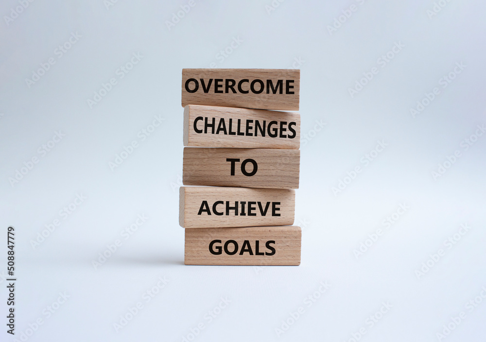 Challenges or goals symbol. Wooden blocks with words 'Overcome challenges to achieve goals'. Beautiful orange background. Business and 'Overcome challenges to achieve goals' concept. Copy space. Challenges or goals symbol. Wooden blocks with words 'Overcome challenges to achieve goals'. Beautiful orange background. Business and 'Overcome challenges to achieve goals' concept. Copy space.