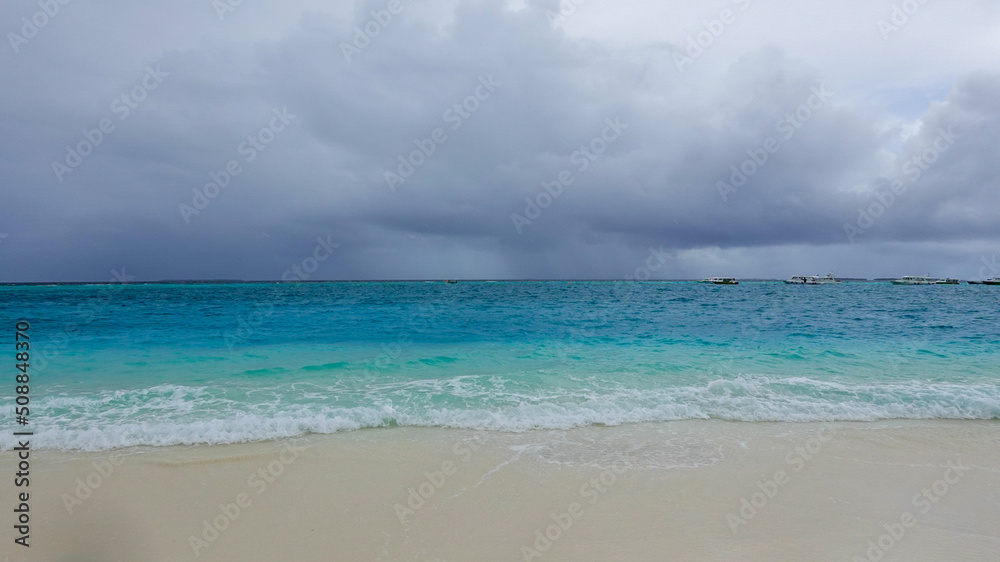 view of an ocean, turquoise water with cloudy sky