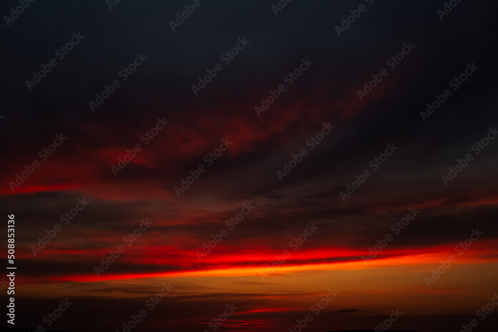 Beautiful landscape of sunset with dark colourful clouds. Natural background.