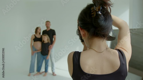 4k footage girl photographer takes pictures of family mom dad daughter waiting for new family member. Photo shooting for memories the pregnancy time waiting for newborn baby child of future maternity