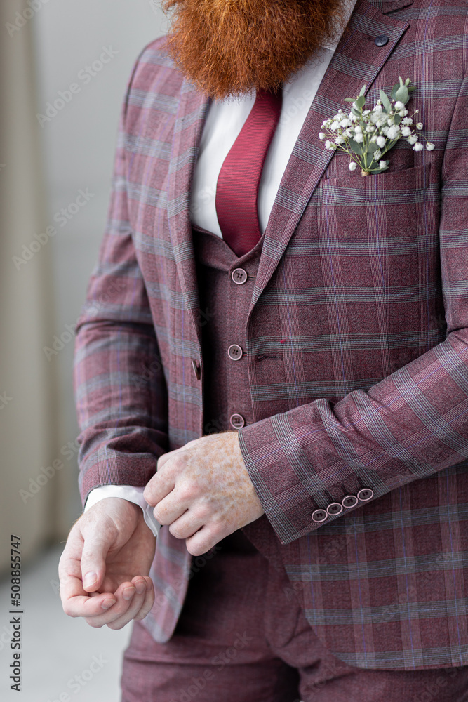 Handsome redhead groom with a beard before wedding ceremony waiting for the bride