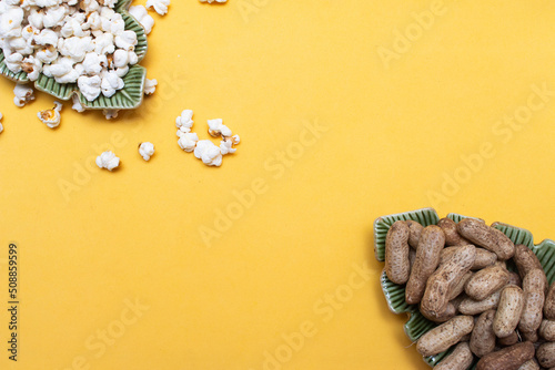 brazilian june party snacks like popcorn, peanuts and corn on a yellow background