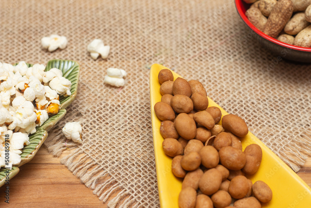 brazilian june party snacks like popcorn, peanuts and corn on straw background brazilian june party snacks like popcorn, peanuts and corn on straw background