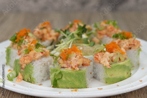 Asian cuisine sushi roll with lobster and shrimp tempura topped with green onion and masago for a very hearty meal