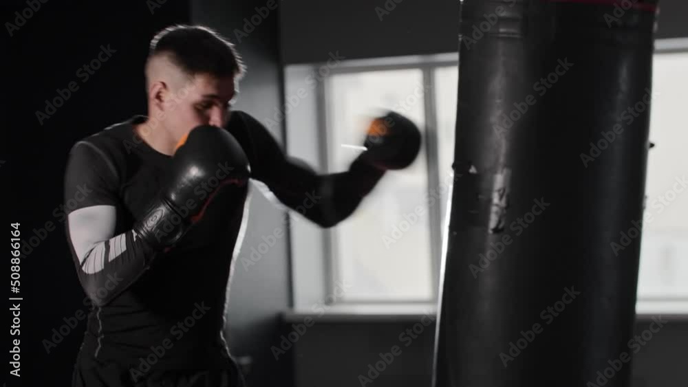 Fit man in the gym hitting the punching bag Fit man in the gym hitting the punching bag