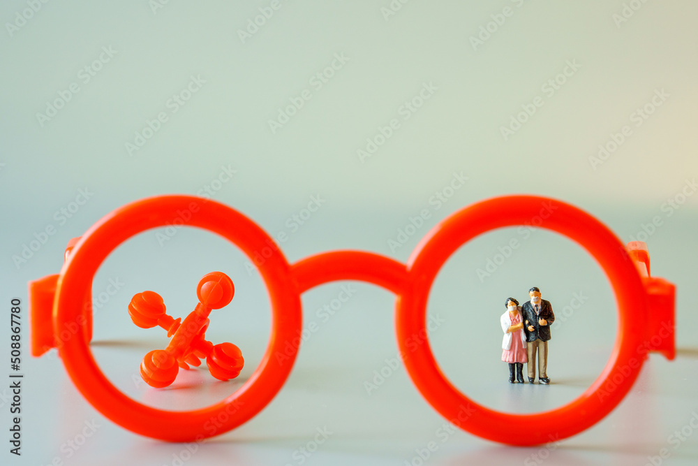 miniature figure old people with mask standing and red virus in frame red glasses miniature figure old people with mask standing and red virus in frame red glasses