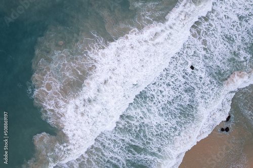 Aerial view sandy beach and waves Beautiful tropical sea in the morning summer season image by Aerial view drone shot, high angle view Top down sea waves
