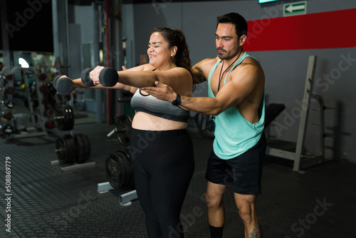 Exhausted fat woman doing weight training