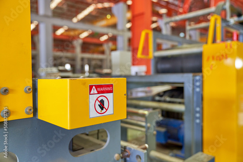 Aafety sign on yellow machine for safety first in metal sheet factory