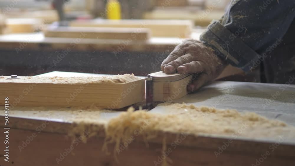 A woodworking milling cutter removes chamfers from the edge of a board with a large amount of sawdust.Carpenter in the workshop, works with wood, makes furniture parts in natural light.Carpentry tools A woodworking milling cutter removes chamfers from the edge of a board with a large amount of sawdust.Carpenter in the workshop, works with wood, makes furniture parts in natural light.Carpentry tools