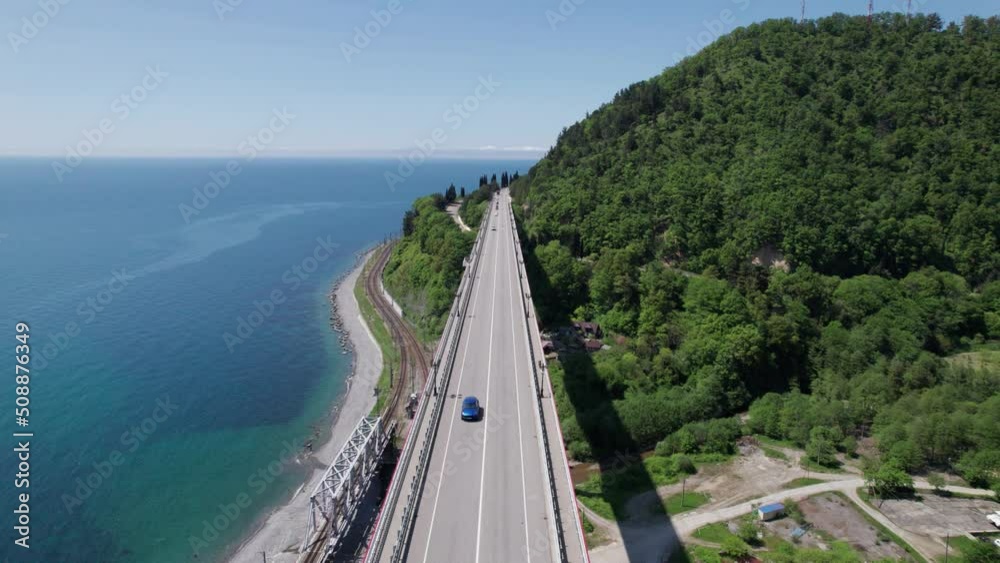 The Zubova Schel Viaduct is a road bridge, Dzhubga - Adler federal road. Aerial view of car driving along the winding mountain road in Sochi, Russia. The Zubova Schel Viaduct is a road bridge, Dzhubga - Adler federal road. Aerial view of car driving along the winding mountain road in Sochi, Russia.