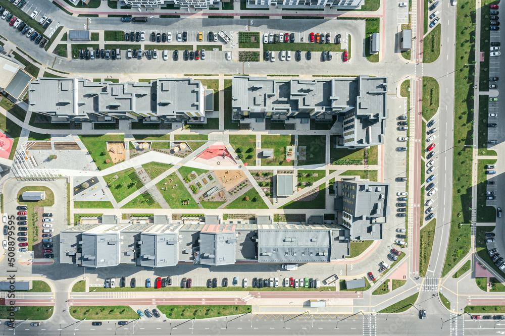 apartment buildings in residential area. playgrounds, cars, parking lots, urban roads. aerial top view.