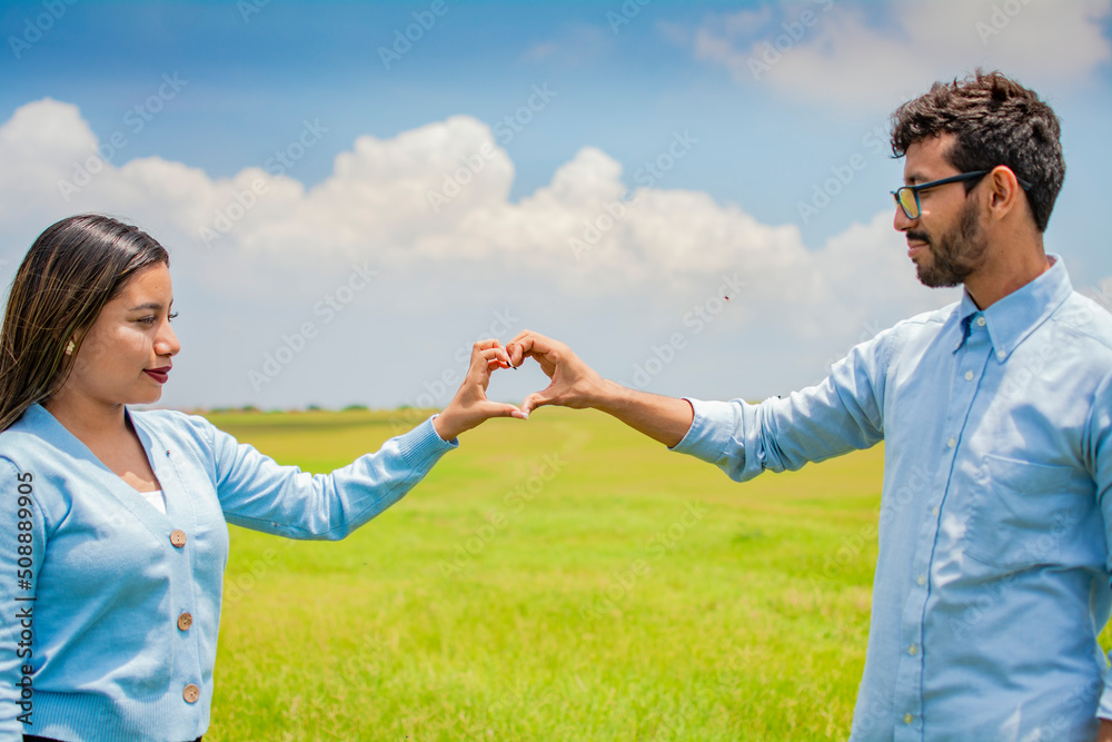 Happy couple making a heart shape with their hands, couple in love in the field making a heart shape with hands, beautiful couple in the field making a heart shape with hands Happy couple making a heart shape with their hands, couple in love in the field making a heart shape with hands, beautiful couple in the field making a heart shape with hands