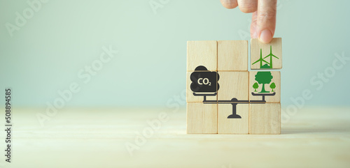 Carbon neutral balancing CO2 emission offset concept. Planting of trees and renewable energy to absorb CO2 in compensation of same amount produced. Carbon offset, limit climate change, global warming. photo