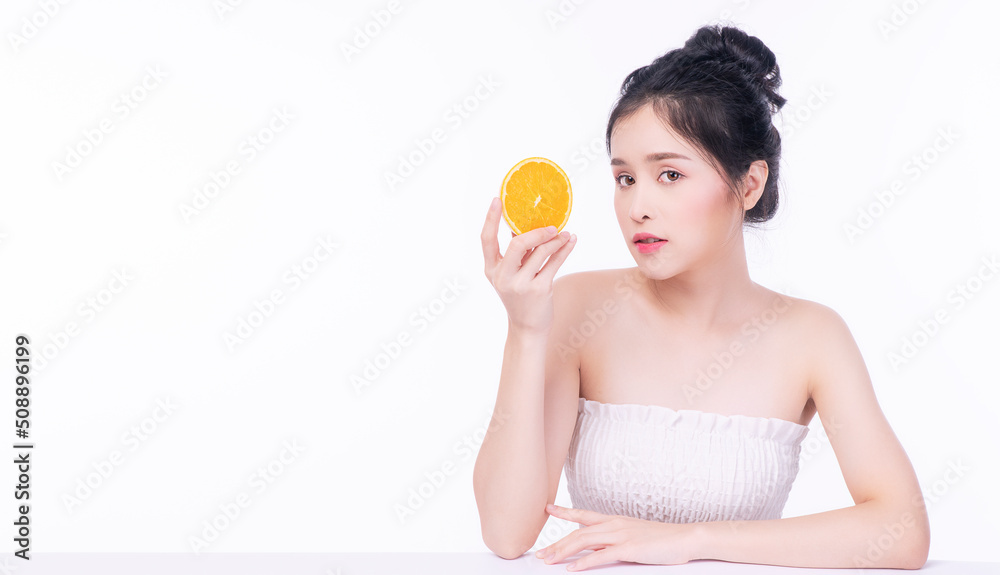 Joyful Asian woman holding freshness orange fruit slices vitamin c for good skin looking at camera over isolated white background. Healthcare complexion vitality or diet lifestyle concept. Joyful Asian woman holding freshness orange fruit slices vitamin c for good skin looking at camera over isolated white background. Healthcare complexion vitality or diet lifestyle concept.