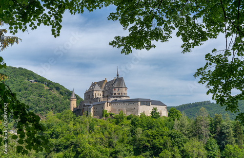 the historic Vianden Castle in Luxembourg framed by lush green summer forest