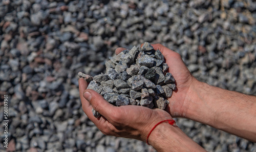 Crushed stones in the hands of a man. Selective focus.
