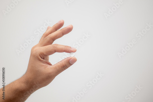 hand holding medicine capsule white background