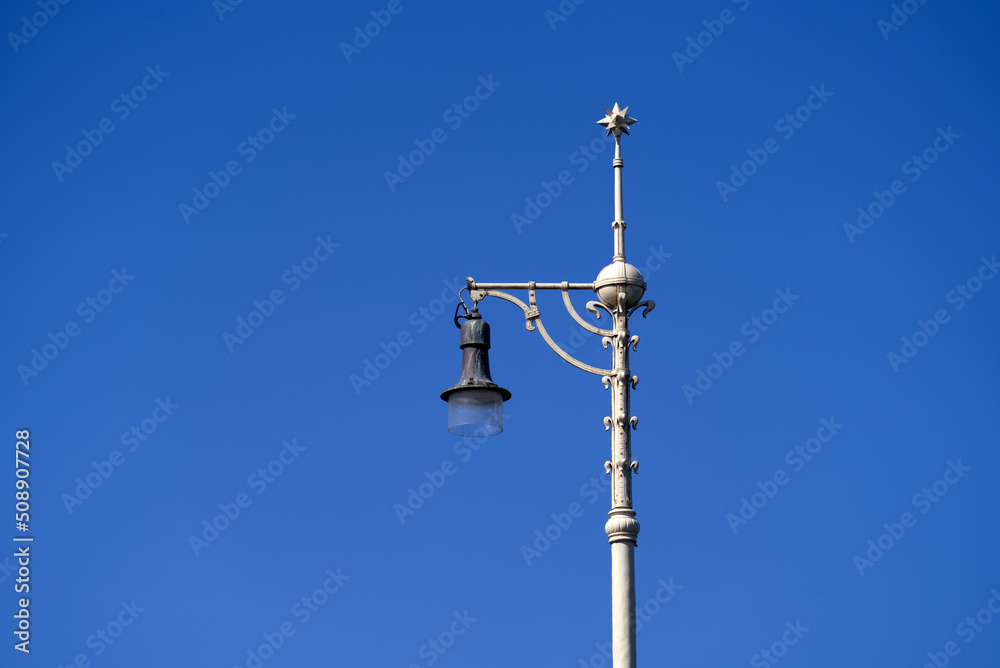 Top of metal street light pole with ornaments at Middle Rhine Bridge at City of Basel on a sunny spring day. Photo taken May 11th, 2022, Basel, Switzerland.