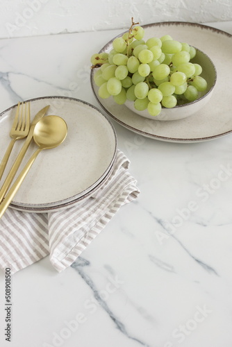 Modern ceramic tableware top view on marble table. Trendy plates, cutlery and linen napkins scandinavian style.Space for text or menu . Business food brand template.