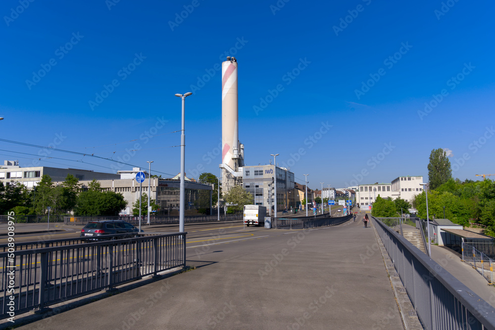 Bridge named Dreirosenbrücke with tramway and chimney of incineration plant in the background at City of Basel on a sunny spring day. Photo taken May 11th, 2022, Basel, Switzerland. Bridge named Dreirosenbrücke with tramway and chimney of incineration plant in the background at City of Basel on a sunny spring day. Photo taken May 11th, 2022, Basel, Switzerland.