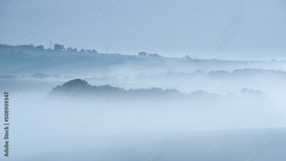 Beautiful vibrant landscape image of sea of fog rolling across South Downs English countryside during Spring sunrise Beautiful vibrant landscape image of sea of fog rolling across South Downs English countryside during Spring sunrise