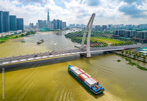 Shipping cargo to harbor by ship  aerial view. Center Ho Chi Minh City  Vietnam with development buildings  transportation  energy power infrastructure  view from Saigon river