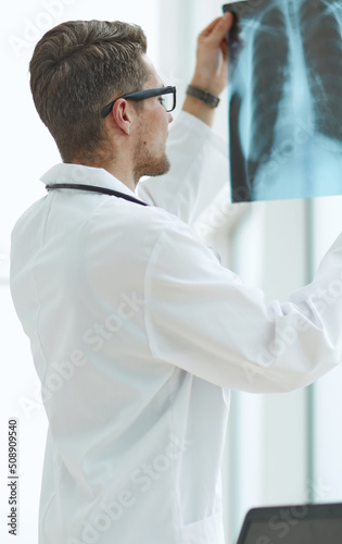 Male doctor radiologist examines x-rays in a medical office.
