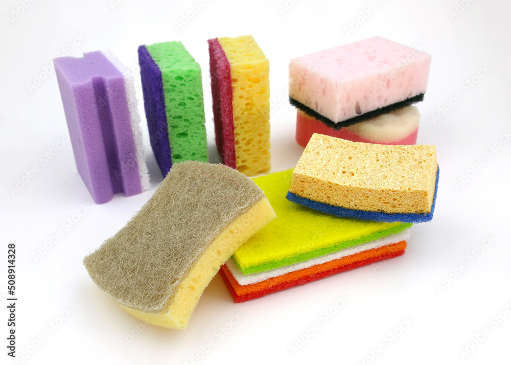 Set of different sponges for washing dishes on a white background. Bright colored sponges for cleaning. Paralon and cellulose sponges for the kitchen. Set of different sponges for washing dishes on a white background. Bright colored sponges for cleaning. Paralon and cellulose sponges for the kitchen.