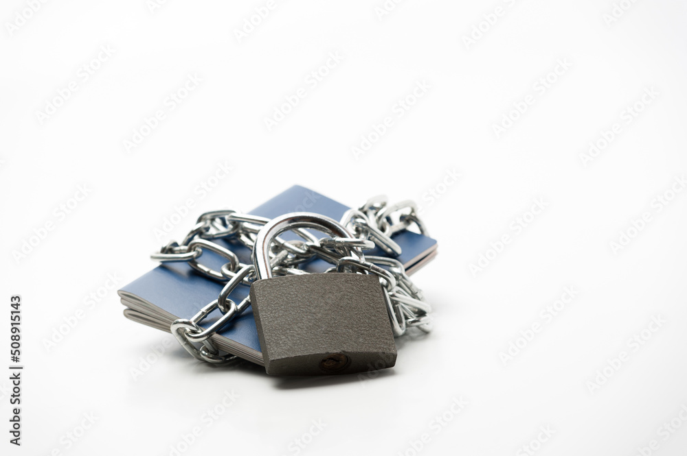 several passports locked with a chain and padlock lying on a white background several passports locked with a chain and padlock lying on a white background