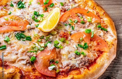 pizza with tuna fish and vegetables on wooden background