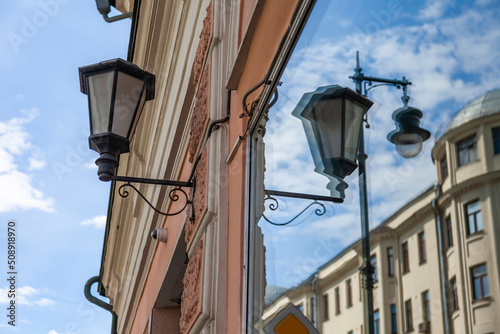 Moscow, Russia, June 4, 2022.  Beautiful street lamps at facade of historical building and its reflection